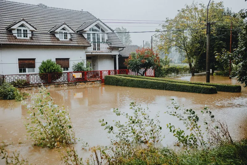 House with a yard under brown floodwater